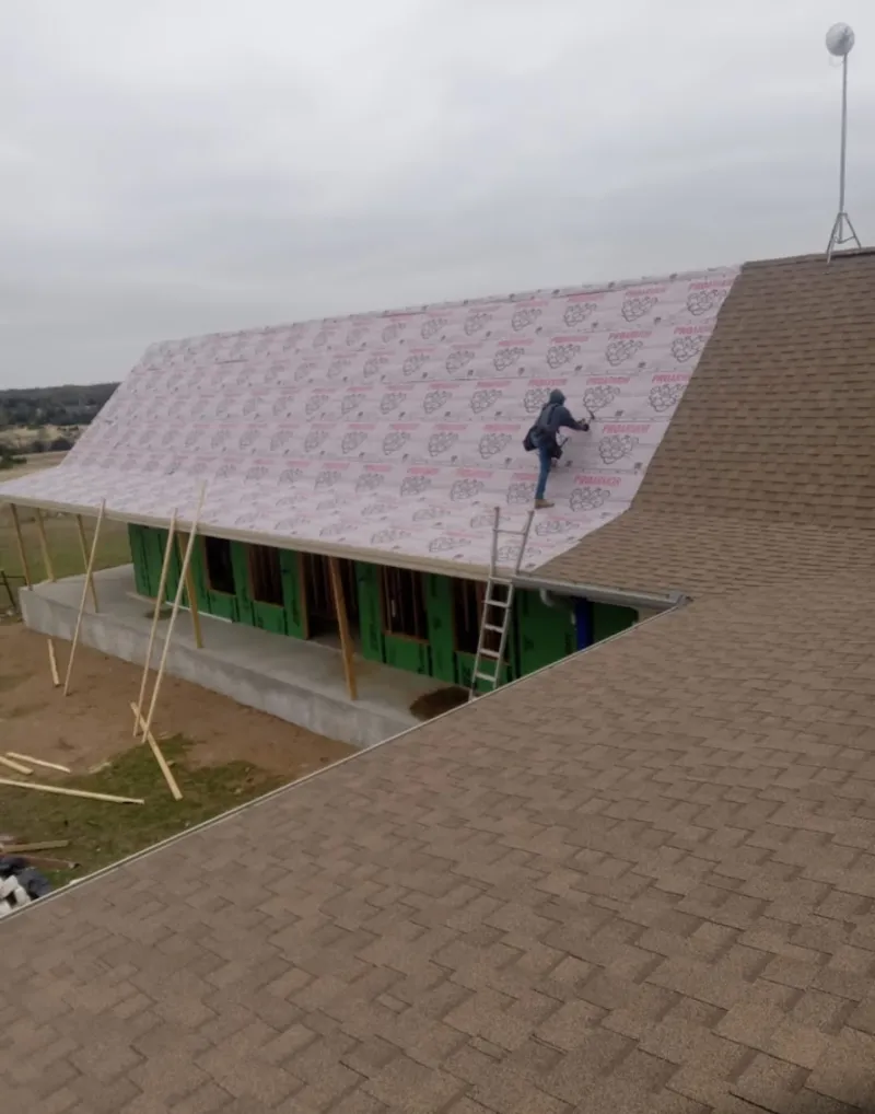 Worker preparing underlayment for a metal roof installation in Middleton